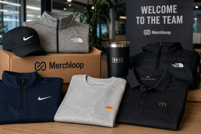 Premium branded employee swag display featuring Nike, The North Face, TravisMathew, Marine Layer, and YETI products in a Merchloop on-demand company store setup with zero inventory and no minimum order quantities.